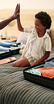 Packing, high five and dad with child with suitcase for travel, vacation and prepare for holiday. Black family, happy and kid with luggage, parent and gesture for help for adventure, getaway and trip