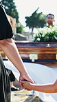 Person, child and holding hands at funeral in cemetery for burial service, parent loss and comfort. Casket, kid or family with emotional support for death, bereavement or empathy in mourning at grave