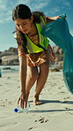 Woman, cleaning and beach with bottle for recycling plastic, save planet or earth day. Female person, volunteer or cleaner with dirt bag for community service or environmental hygiene on sandy shore