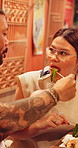 Couple, feeding and dining with food in thai restaurant for dinner date, meal or snack together. Asian man, woman and eating with sticks for cuisine, recipe or tasting in Japan restaurant or store