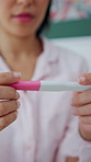 Pregnancy test, hands and woman on bed in home with anxiety for family planning or bed news. Maternity, waiting and person with fertility stick in bedroom with concern, scared or stress in house.