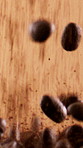 Blended, roasted and coffee beans falling with seeds, production and organic textures for caffeine. Rustic, granules and arabica grain for manufacturing, process and rich flavor on studio background
