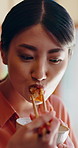 Asian woman, eating and food at house with chopsticks, healthy rice and traditional meal for lunch. Female person, bowl and utensils in home for brunch, nutrition snack and authentic Chinese cuisine 