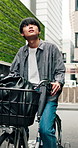 Travel, man and explore with bicycle in town for morning commute, adventure and journey. Happy, cycling and Japanese person on bike for urban trip, sustainable or eco friendly transport outdoors