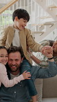 Dad, carry and shoulder with child on sofa for family time, bonding or weekend together in home. Father, kid or playing with mom or sibling on living room couch for holiday or vacation in house