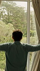 Window, stretching and back of man in home to start day, morning routine and sunlight. House, accommodation and person open curtains for view, sunshine and nature for fresh air, wellness and weather