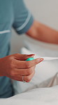 Hand, thermometer and sick person in bed with care, disease and virus infection at home. Temperature check, woman and monitor flu symptoms for health, cold or fever with recovery support at bedroom