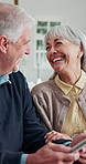 Senior couple, home and laugh with tablet, agreement and handshake with financial advisor in lounge. Old people, online and reading investment report, shaking hands and happy with technology in house