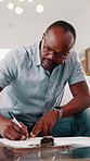 Finance, documents and black man writing in home for investment, tax assessment or budget planning. Male person, accounting or checking paperwork with invoice for financial report, expenses or bills