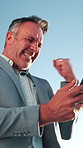 Businessman, winning and celebration with phone for lottery prize, promotion or outdoor success. Excited, mature or male person with smile, fist pump or blue sky for victory, achievement or good news