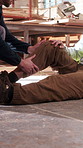 Injury, help and construction workers on site with accident, fall or leg fracture on duty. Muscle sprain, men and civil engineers with assistance for torn ligament, knee pain or medical emergency.