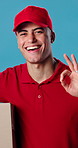 Box, face and delivery with happy man in studio for perfect package on a blue background. Portrait, male person or courier guy with smile, like emoji or OK sign for shipping or transportation service