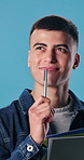 Books, thinking and man in studio for university, college and decision for learning and studying. Happy, pen and student with textbooks, solution and idea for education, school and blue background