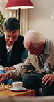 Caregiver, playing and old man in home with chess, strategy and competition with cognitive games. Nurse, piece and senior person on sofa with chessboard, contest tactics and skills for friendly match