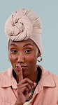 Face, hush and black woman with finger on lips in studio for secret, news or announcement. Whisper, emoji and portrait of African person with gossip, drama or did you know info on blue background