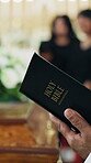 Funeral, bible and hands in church with scripture, religious sermon and mourning with spiritual reading. Preaching, man or priest with holy book, grief verse or Christian guidance in memorial service
