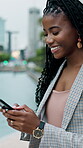 Laugh, texting and businesswoman in city with phone, online communication and comic post on social media. Happy, black woman or employee in town with tech, funny message or meme reaction on chat app
