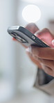 Person, hands or typing with phone in office for research, social media or online connectivity. Closeup, employee or scrolling with smartphone for communication, web search or mobile app in workplace