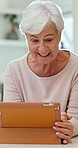 Happy, tablet and senior woman in house with notification, blog or online newsletter in living room. Smile, digital technology and elderly person in retirement watching video on app in apartment.
