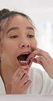 Mirror, woman and dental floss in bathroom for teeth, morning routine or clean gums for fresh breath. Person, smile and check mouth in home with reflection, string and plaque removal for oral health.