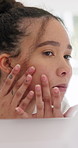 Woman, skincare and face inspection in mirror with morning routine, hair care or grooming in bathroom. Person, skin evaluation or dermatology in home with reflection, check hairstyle or getting ready