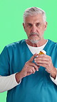 Face, man and nurse with pills for dose, prescription and healthcare on green background. Mature person, medical worker and medicine with instruction for wellness, advice and talking in studio