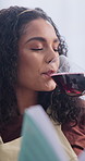 Red wine, thinking and woman with book in home with relax, calm or satisfaction on weekend break. Happy, reflection and person drinking alcohol beverage for peace, nostalgia or positive attitude.