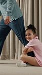 Walking, hang and child on leg of father in home for safety, attachment or weekend connection. Happy, family and girl kid clinging to dad for security, separation anxiety or bonding in house.