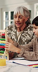 Learning, grandma and child with abacus in home for mental math, problem solving and homework. Homeschool, senior woman or kid with bead counting for calculation practice, education or family support