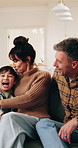 Excited, kiss and parents on sofa with kids for bonding, connection or security in home. Conversation, relax and surprise with children running in apartment for development or family relationship