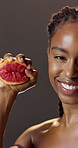 Face, grapefruit and smile with black woman in studio for diet, health benefits or nutrition. Food, juice and squeeze with happy person on dark background for antioxidants, skincare or vitamin c