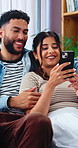 Happy, couple and relax at house with phone, social media and website for online shopping. Smile, people and talking in lounge with mobile, browsing catalog and multimedia subscription for ecommerce