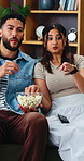 Movie, pointing and couple on sofa with popcorn in home with subscription service for bonding. Love, eating and man with woman for streaming film, watching tv show or joke for date with snack