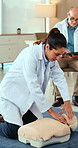 Doctor, demonstration and dummy for first aid training at hospital for workshop, lift chin or protocol. Woman, healthcare team and emergency procedure for choking, breathing and demo or teaching