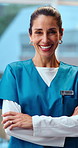 Face, nurse and smile in hospital with arms crossed, assistance and medical advice for wellness. Portrait, mature woman and happy in workplace with employee, positive attitude and healthcare services