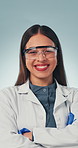 Face, woman and scientist in studio with arms crossed, career pride and about us for research. Portrait, female person or smile with goggles, medical study or healthcare experiment on blue background