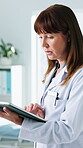 Medical, review or woman in hospital with tablet, research or patient diagnosis in online consultation. Healthcare, typing or mature doctor with tech, telehealth or case report for treatment plan.