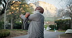 Elderly, fitness and black man stretching in street for outdoor workout preparation or exercise. Senior, active or male person getting ready with arm warm up on road for training, health or wellness