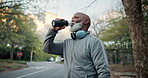 Senior, fitness and black man with water in nature for hydration, sustainability or outdoor nutrition. Elderly, active or male person with mineral liquid beverage for workout break, rest or recovery