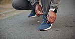 Person, hands and tying with shoes in road for outdoor workout preparation, safety or running. Active, runner or getting ready with sneakers or laces for exercise, training or fitness on street