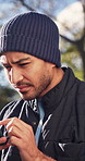 Texting, confused and man in park with phone, miscommunication and surprise message on chat app. Digital, bokeh and person outdoor with tech, networking issue and unclear response on virtual platform