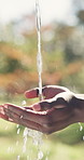 Water, organic and person washing hands outdoor for hygiene, health or self care in countryside. Sustainability, nature and liquid for cleaning skin for dirt, germs or bacteria removal on farm.