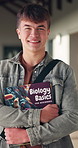 Happy, high school and face of boy with textbook in corridor for learning, education and biology course. Portrait, student and teenager with books for lesson, development and science at academy