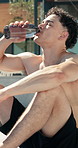 Fitness, outdoor and man water bottle on break, rest and exhausted after intense workout. Male person, tired athlete and drinking to hydrate for wellness, health and training exercise in summer