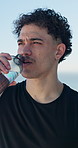 Fitness, outdoor and man drink water on break, rest and exhausted after intense workout. Male person, tired athlete and bottle to hydrate for wellness, runner and training exercise in summer