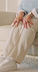 Senior, woman and hands with knee pain in home for discomfort, muscle tension or recovery. Elderly, female person or pensioner with sore legs or massage on sofa for arthritis or fibromyalgia in house