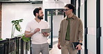 People, walk and discussion in office with tablet, social media marketing campaign and online research. Creative, men and talk in business corridor with tech, advertising project review and planning.