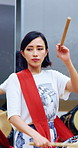 Asian woman, group and practice with drumsticks in class for taiko tradition, culture or performance. Band, Japanese musician and teacher person with skill for music lesson, sound or percussion art