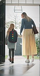Leaving, mom and child at front door in home ready for school, work and commute together. Family, house and back of mother and girl holding hands for education, career or morning routine to start day