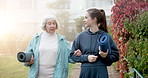 Walking, outdoor and woman with senior person for health, mobility and fresh air at retirement center. Happy, morning and people with exercise mat, talking and bonding for wellness, active and care